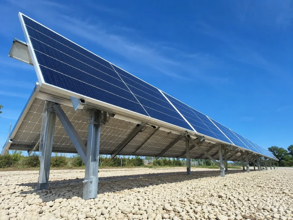 Bifacial solar panel installed on an elevated ground mount, positioned to capture reflected sunlight from below.