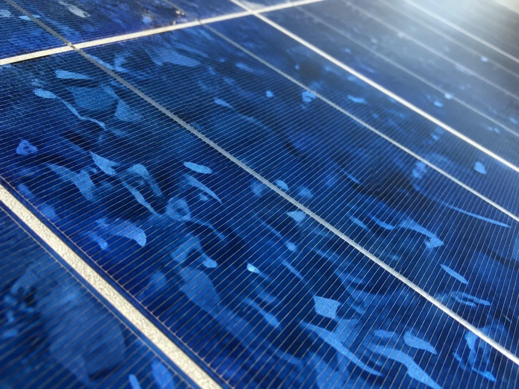 Close-up of polycrystalline solar panel cells showing the characteristic blue, speckled crystal texture.